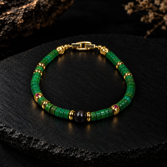 Archean · 太古 — green turquoise heishi beads with gold-plated accents and a black stony meteorite center bead, photographed on dark slate