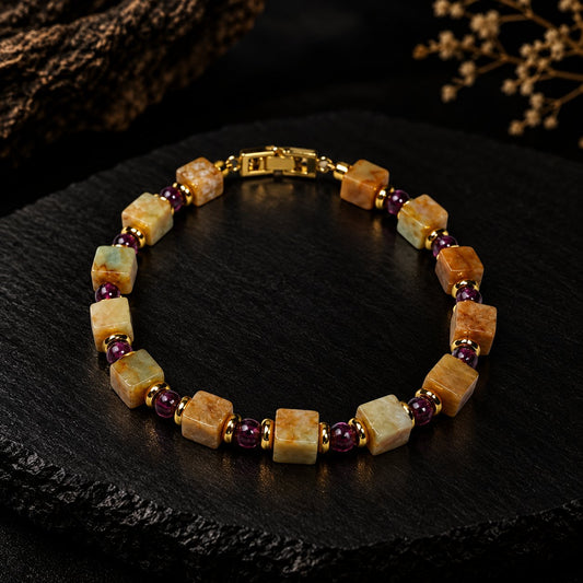 Terra · 坤舆 — square-cut old jade and round garnet beads with gold-plated spacers and clasp, photographed on dark slate